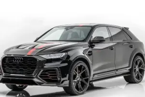 만소리, 아우디 RS Q8 튜닝 공개…780마력으로 업그레이드 후드와 휠에 빨간색으로 포인트를 준 세련된 검은색 아우디 SUV로, 흰색 바탕에 3/4 각도로 표시됩니다. 이 차량은 스포티한 스타일링과 대형 블랙 알로이 휠이 특징입니다.
